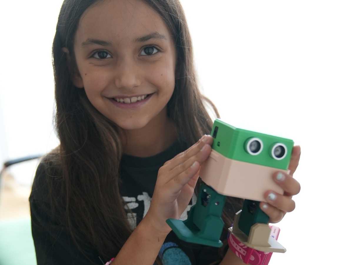 Mädchen hält selbstgebauten Roboter im Robbo Club