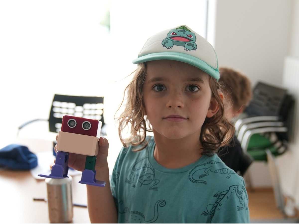 Kind zeigt Lernroboter nach dem Robbo Club Unterricht