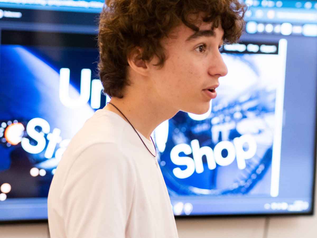 Jugendlicher erklärt digitale Inhalte vor einem Bildschirm