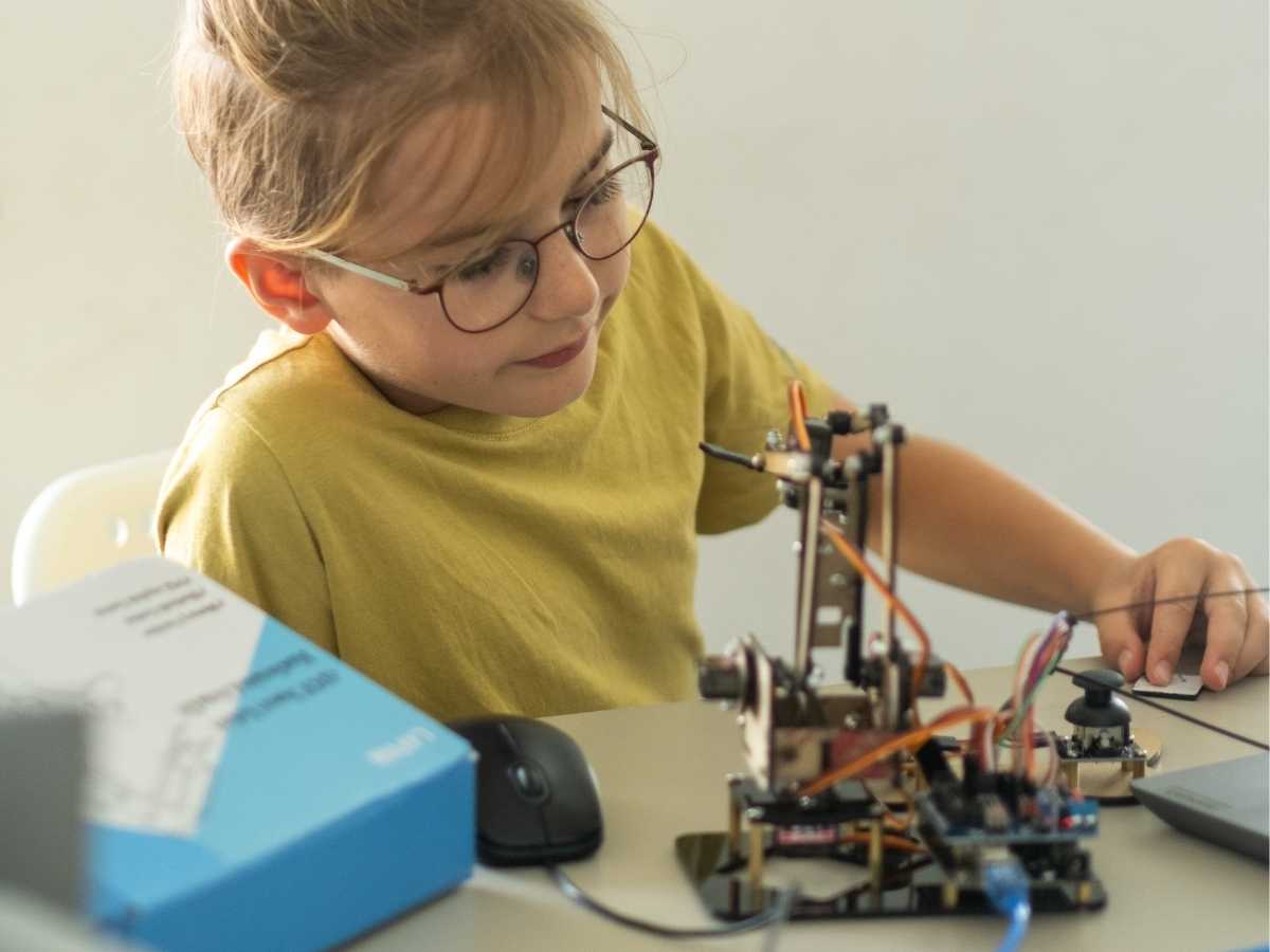 Kind arbeitet konzentriert an einem Robotik-Bausatz im Robbo Club Wien