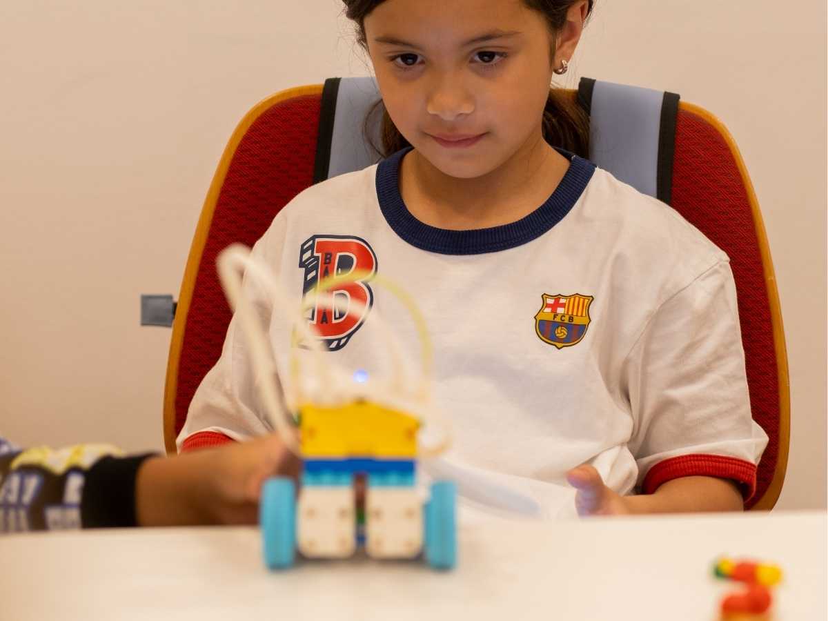 Kind testet selbstgebauten Lernroboter im Elektronikunterricht