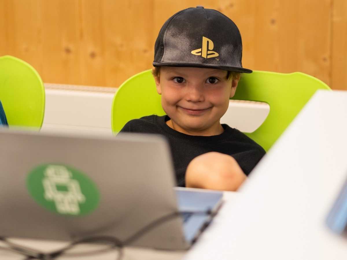 Kind arbeitet konzentriert am Laptop im Robbo Club Sommer-Camp