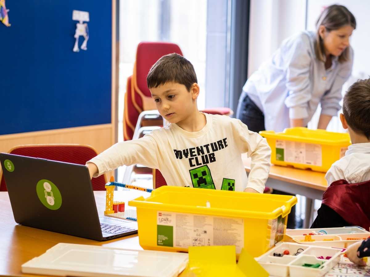 Kind programmiert und baut mit Baukasten und Laptop im Robbo Club