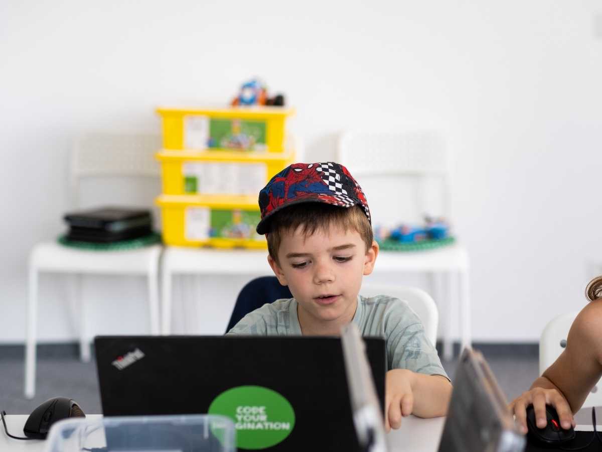 Kind programmiert am Laptop im Technikunterricht des Robbo Club