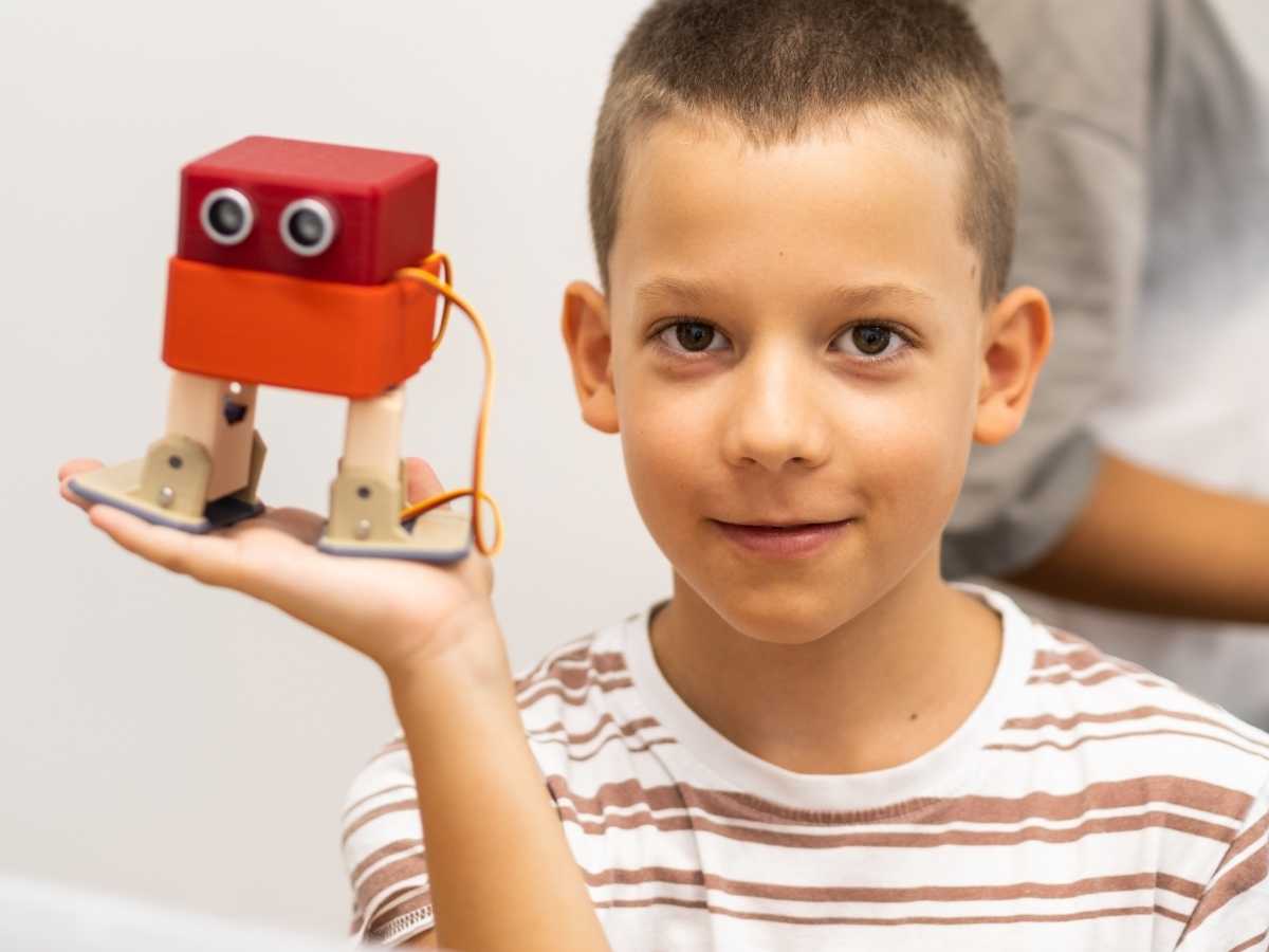 Kind zeigt selbstgebauten Roboter im Robbo Club