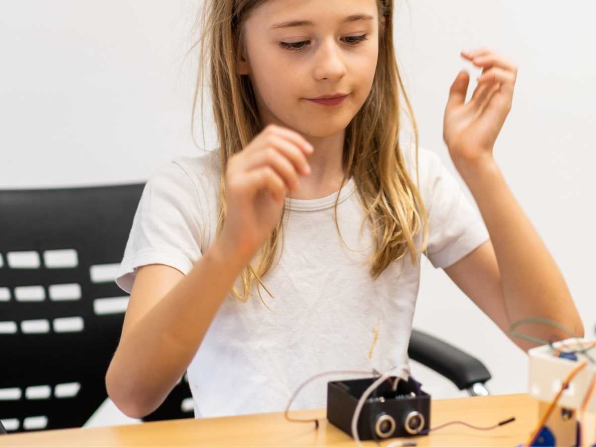 Kind arbeitet mit elektronischen Bauteilen im Robbo Club Technikunterricht