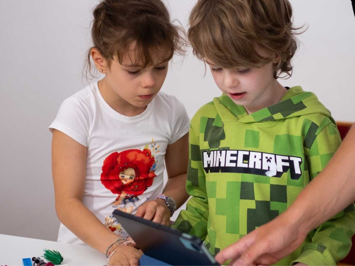 Kinder arbeiten gemeinsam mit Tablet im Robbo Club Lerncamp