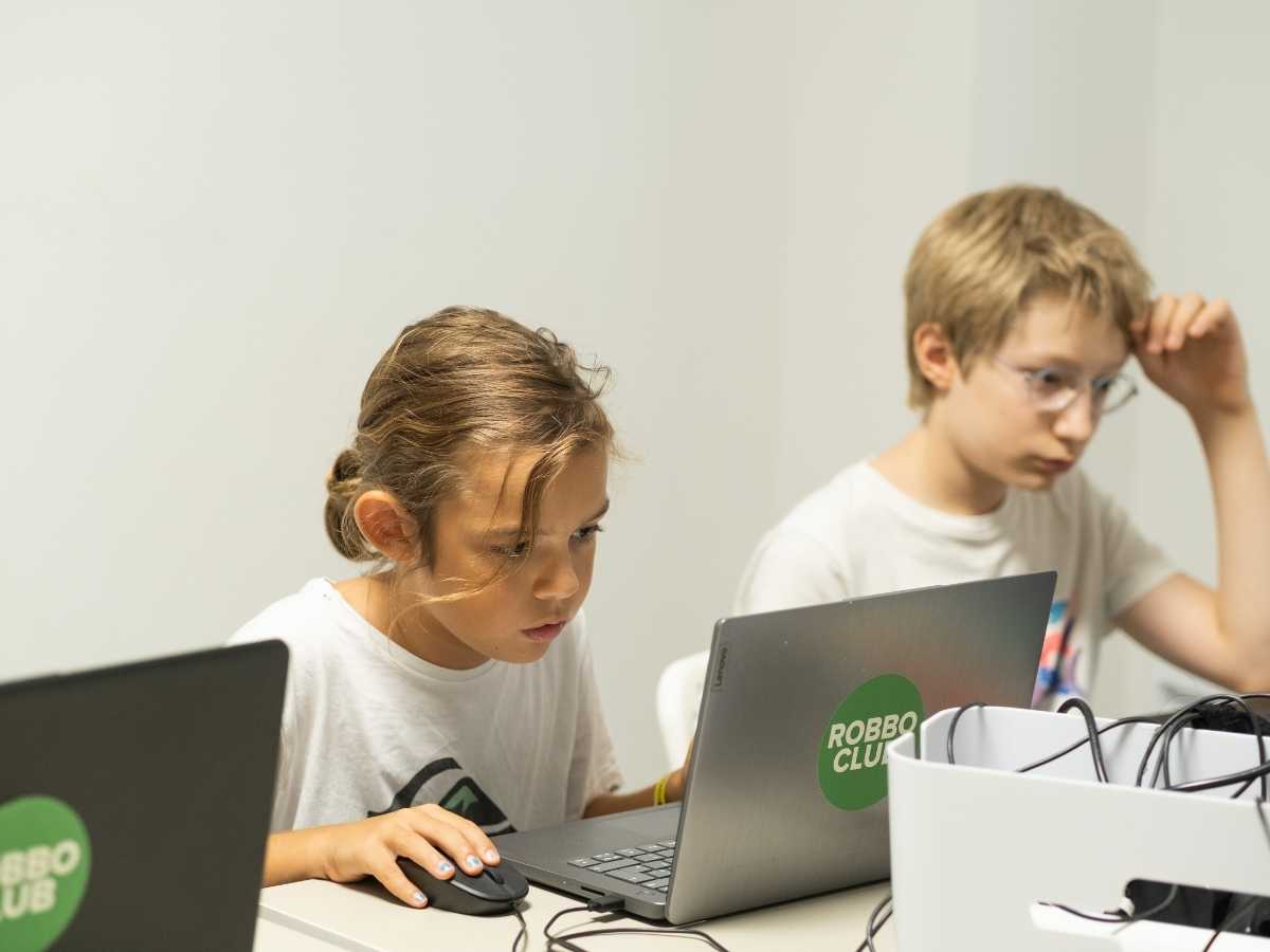 Kinder programmieren gemeinsam am Laptop im Robbo Club Wien