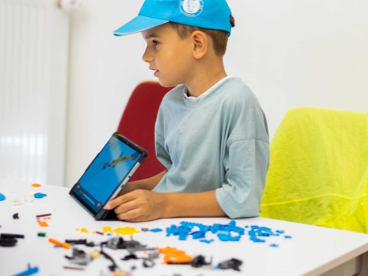 Kind nutzt Tablet und LEGO Bauteile im Robotik-Unterricht