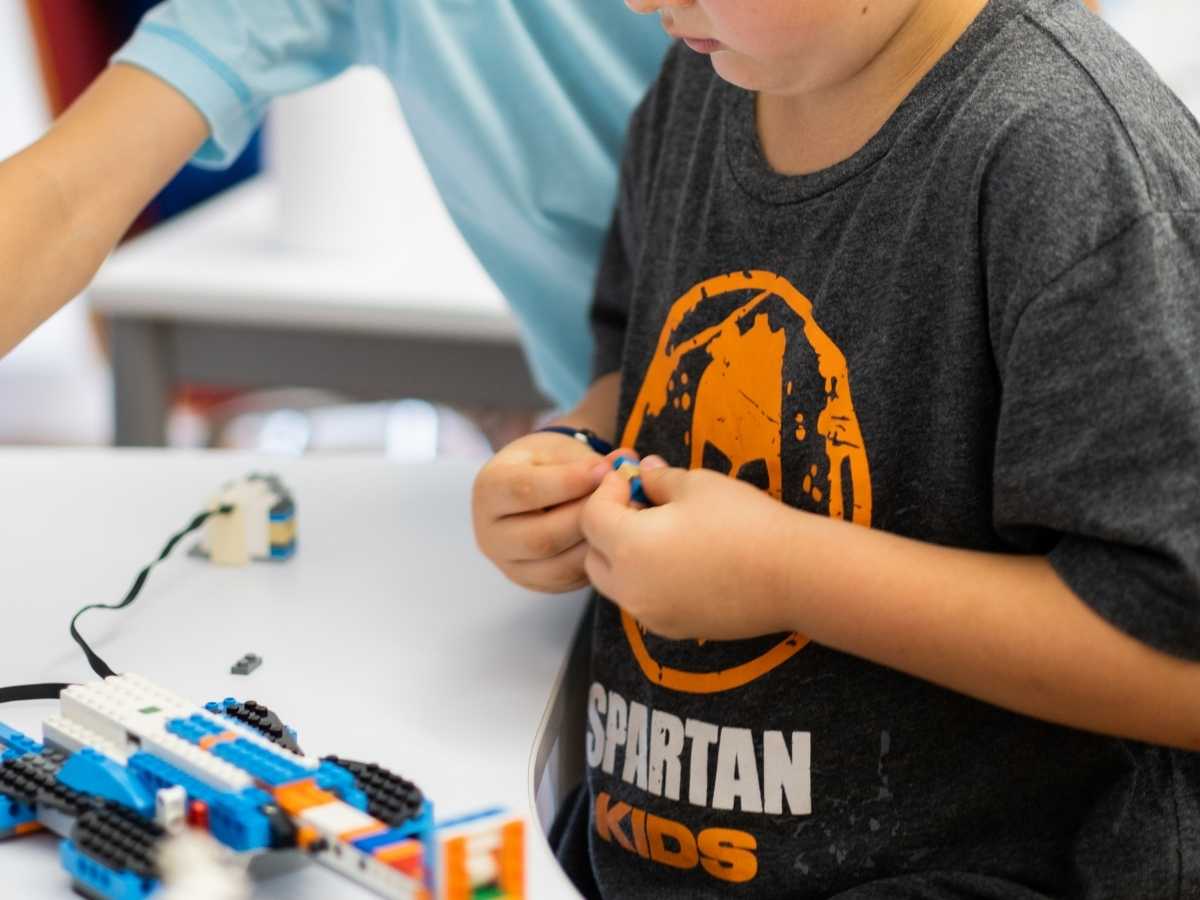 Kind baut LEGO Roboter und trainiert Feinmotorik