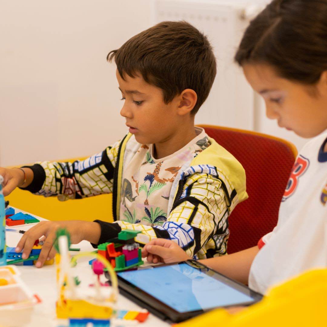 Kinder programmieren LEGO Education® Modelle mit Tablet im Sommer-Camp