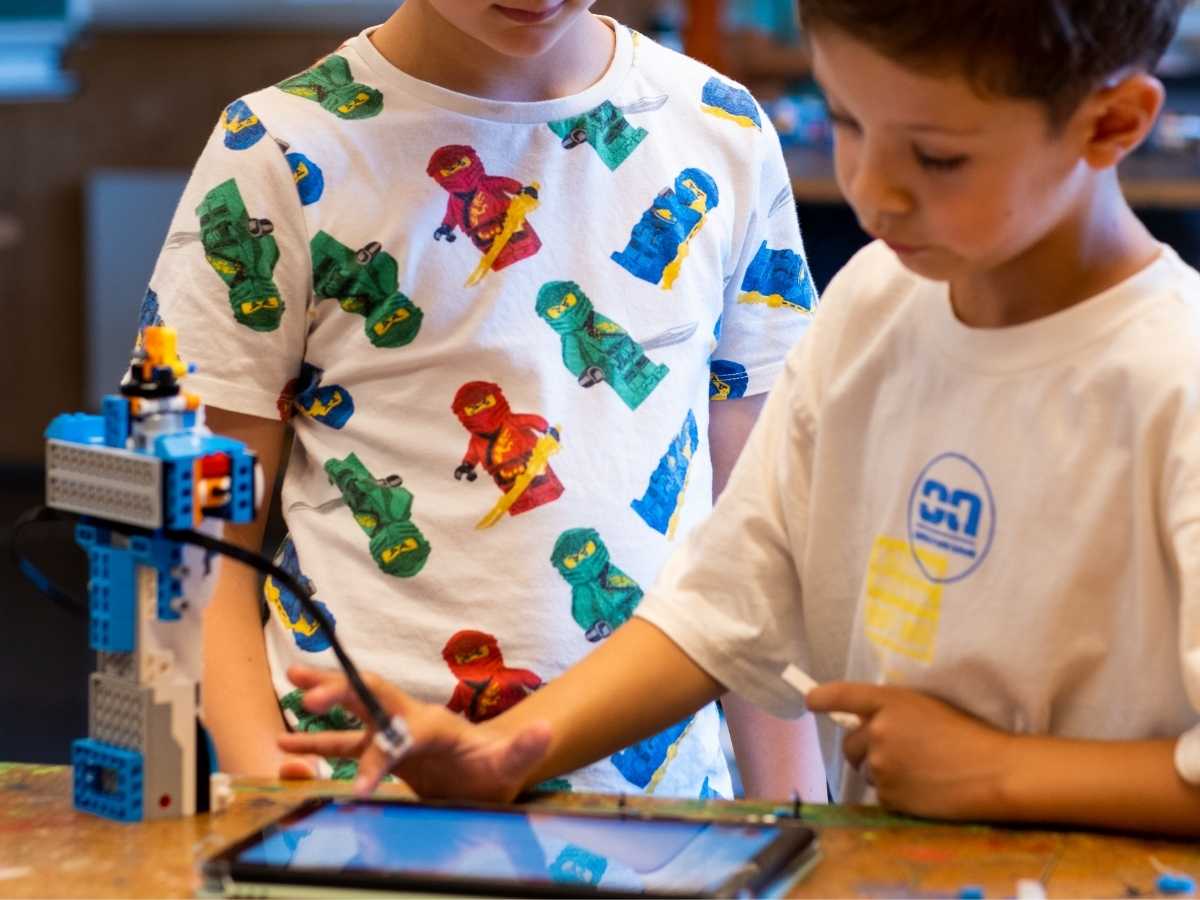 Kinder programmieren Roboter mit Tablet im ROBBO Club