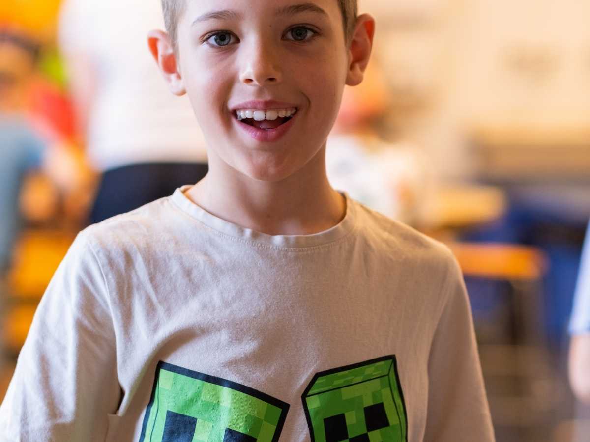 Junge lächelt in die Kamera während eines Technik- und Programmierkurses im Robbo Club