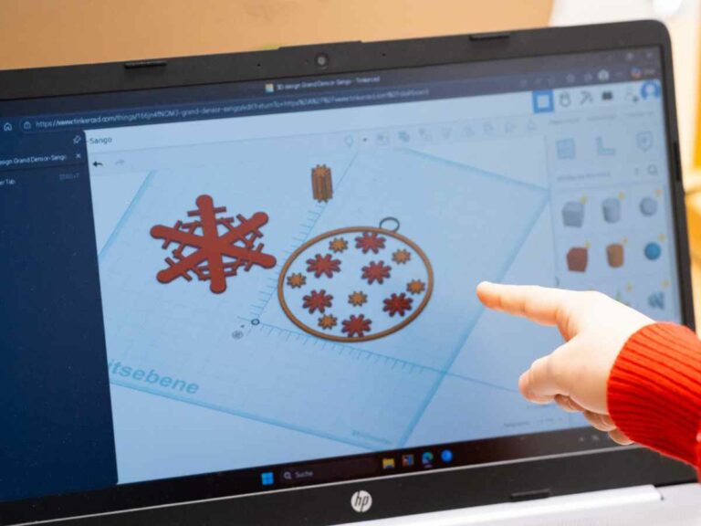 Christbaumschmuck in Tinkercad: Ein Kind zeigt am Laptop auf sein Modell