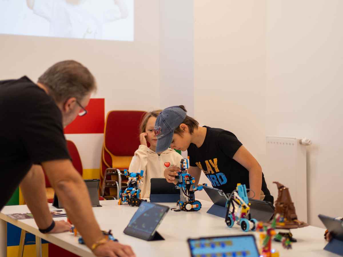 Kinder und Trainer arbeiten gemeinsam an LEGO-Robotern