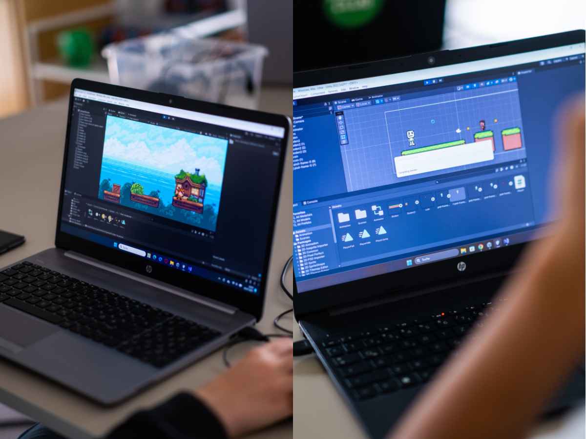Zwei Laptops mit geöffnetem Unity-Editor, auf denen Kinder eigene 2D-Spiele entwickeln.
