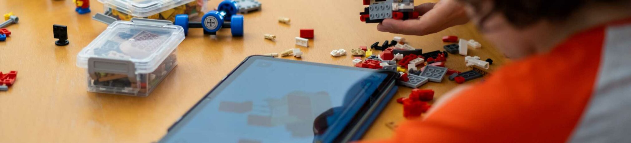 Kind baut LEGO Modell mit Tablet-Anleitung im ROBBO Club Wien