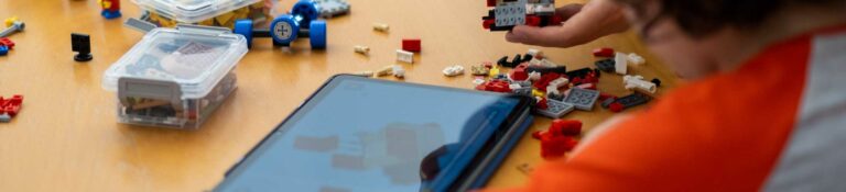 Kind baut LEGO Modell mit Tablet-Anleitung im ROBBO Club Wien
