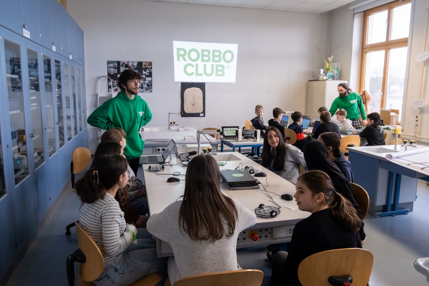 Kinder arbeiten in großer Gruppe an Robotik-Projekten im ROBBO Club Wien